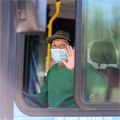 masked bus driver waving